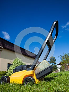 Gardening. Mowing lawn with yellow lawnmower