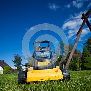 Gardening. Mowing lawn with yellow lawnmower