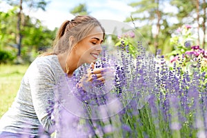Young woman smelling lavender flowers in garden
