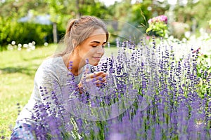 Young woman smelling lavender flowers in garden