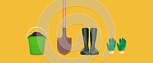 Gardening set tools - gloves, rubber boots, shovel and plastic bucket with soil isolated on yellow background