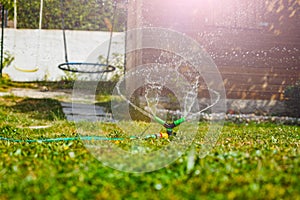 Gardening sprinkle irrigate garden lawn spraying water close-up photo