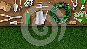 Gardening tool equipment. Top view on wooden table, lawn grass background with copy space. Online shopping commerce or advertising