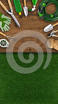 Gardening tool equipment. Top view on wooden table, lawn grass background with copy space. Online shopping commerce or advertising