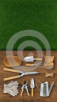 Gardening tool equipment. Top view on wooden table, lawn grass background with copy space. Online shopping commerce or advertising