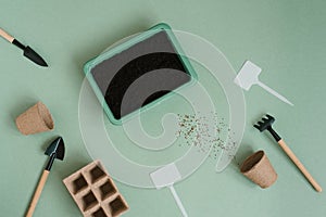 Gardening tool kit for a gardener on a green table background. The concept of spring gardening, a home hobby for the whole family