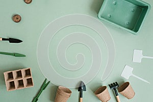 Gardening tool kit for a gardener on a green table background. The concept of spring gardening, a home hobby for the whole family