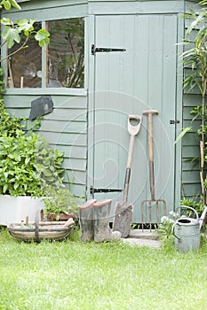 Gardening Tools Against Door Of Shed