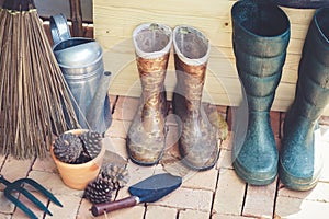 Gardening tools. Equipments for home gardening such as digging tools, spoon and fork shovels, watering can and plastic boots.