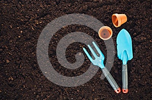 Gardening tools on garden soil texture background top view