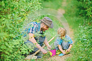 Gardening tools. Gardening hobby. Dad teaching little son care plants. Spring gardening routine. Planting flowers