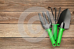 Gardening tools on grey wooden background, top view