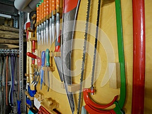 Gardening tools hanging on the wall in a tool shed.