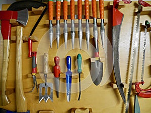 Gardening tools hanging on the wall in a tool shed. High quality photo