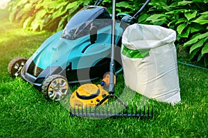 Gardening tools and lawn care equipment on green grass