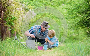 Gardening tools. Planting flowers. Dad teaching little son care plants. Little helper in garden. Make planet greener
