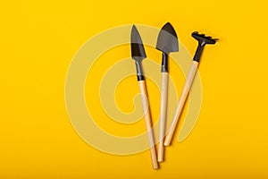 Gardening tools, pruner, gardening gloves, shovel and rake on background.