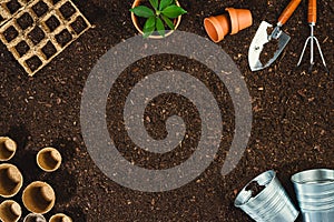 Gardening tools on soil texture background top view.