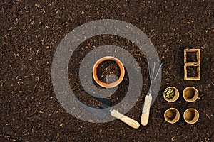 Gardening tools on soil texture background top view.