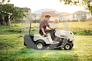 Gardner mowing lawn with ride-on tractor