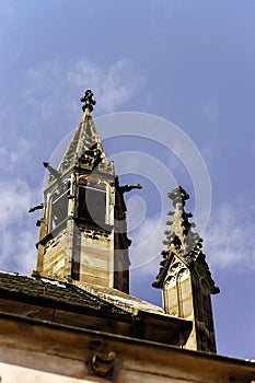 Gargoyle on a gothic cathedral, detail of a tower on blue sky ba