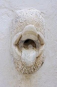 Gargoyle in the shape of tongues of a house in the old town of Martina Franca, Puglia