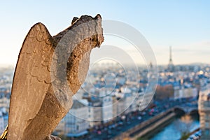 Gargoyle with wings looking at Paris skyline