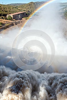 The Gariep Dam overflowing. A rainbow is visible