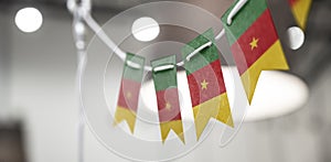 A garland of Cameroon national flags on an abstract blurred background