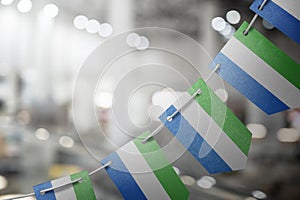 A garland of Sierra Leone national flags on an abstract blurred background