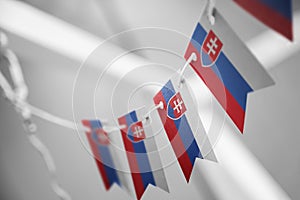 Girlanda národných vlajok Slovenska na abstraktnom rozostrenom pozadí