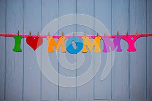 Garland with text `I love mommy` of colorful paper alphabet