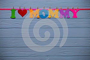 Garland with text `I love mommy` of colorful paper alphabet