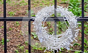 Garland with white LED lamps on a black metal fence