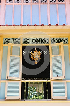 Garlands of flowers hanging on the windows of yellow and blue buildings in public areas