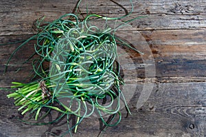 Garlic arrows. A bunch of greens on the table. Vegetable healthy vitamin food. Green stalks seedlings for salad and