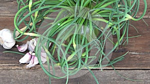 Garlic arrows. A bunch of greens on the table. Vegetable healthy vitamin food. Green stalks seedlings for salad and