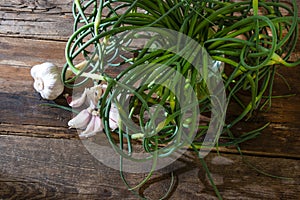 Garlic arrows. A bunch of greens on the table. Vegetable healthy vitamin food. Green stalks seedlings for salad and