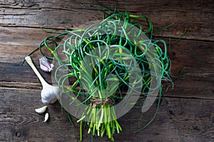 Garlic arrows. A bunch of greens on the table. Vegetable healthy vitamin food. Green stalks seedlings for salad and