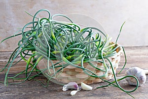 Garlic arrows. A bunch of greens on the table. Vegetable healthy vitamin food. Green stalks seedlings for salad and