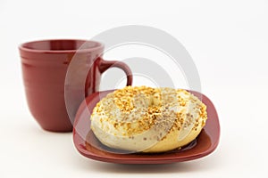 Garlic bagel with red plate and mug