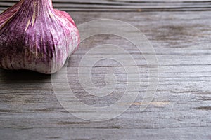 Garlic on a blurry wooden background. Selective focus. Space for lettering and design