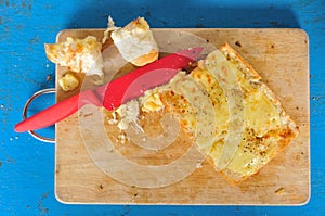 Garlic bread with red knife on the chopping block