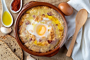 Garlic and bread soup Castilian, from Spain in clay pot and its main ingredients. View from above.