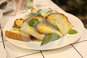 Garlic bread with sweet basil in white dish