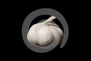 Garlic bulb on a black background. Unpeeled garlic bulb with tenderloin