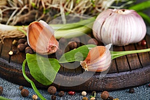 Garlic, chives, rudiments and peas of pepper on a wooden background photo