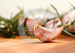 Garlic clove with fresh rosemary in background