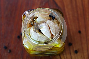 Garlic confit preserved in olive oil with herbs an