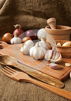 Garlic on cutting board , close-up on sacking. burlap background